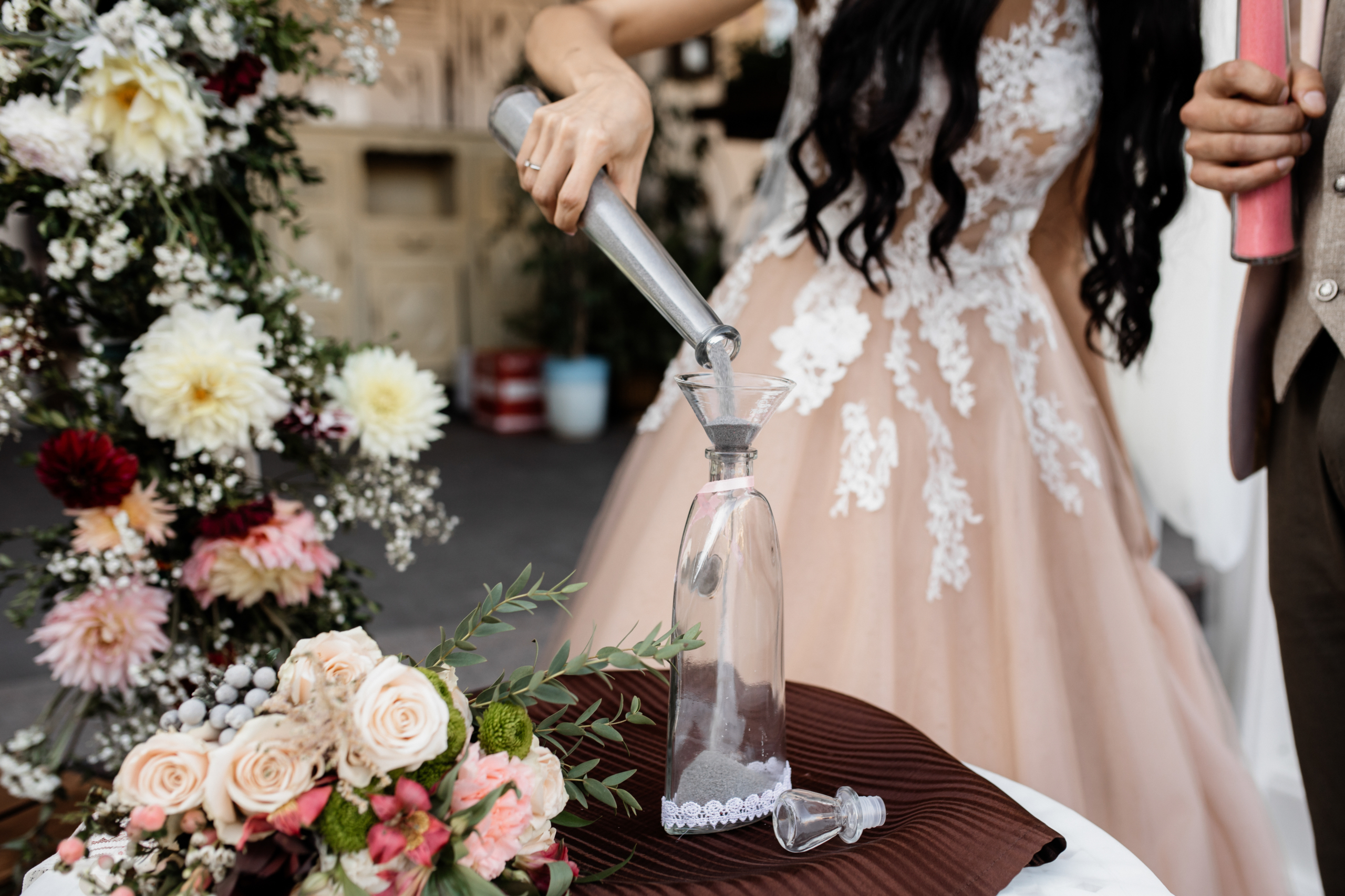 bride pours grey sand bottle scaled
